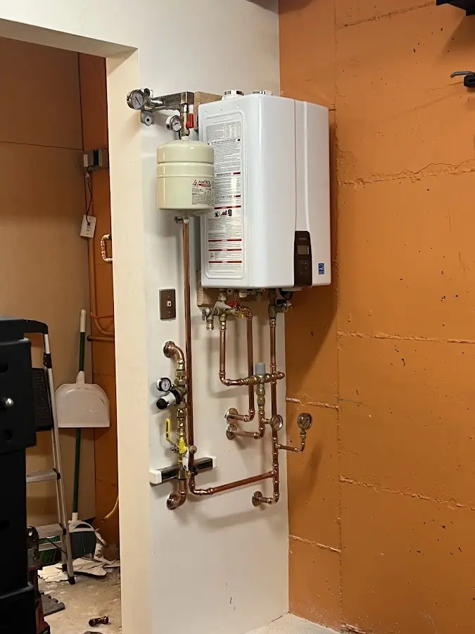 Plumbing technician inspecting water heater connections in Montecito